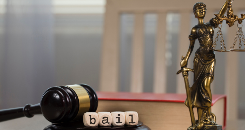 wood blocks spell bail next to gavel and lady justice statue