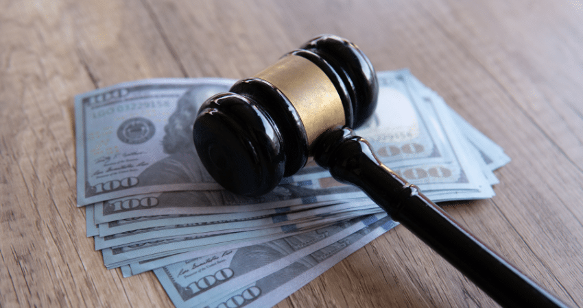 gavel laying on stack of hundred dollar bills