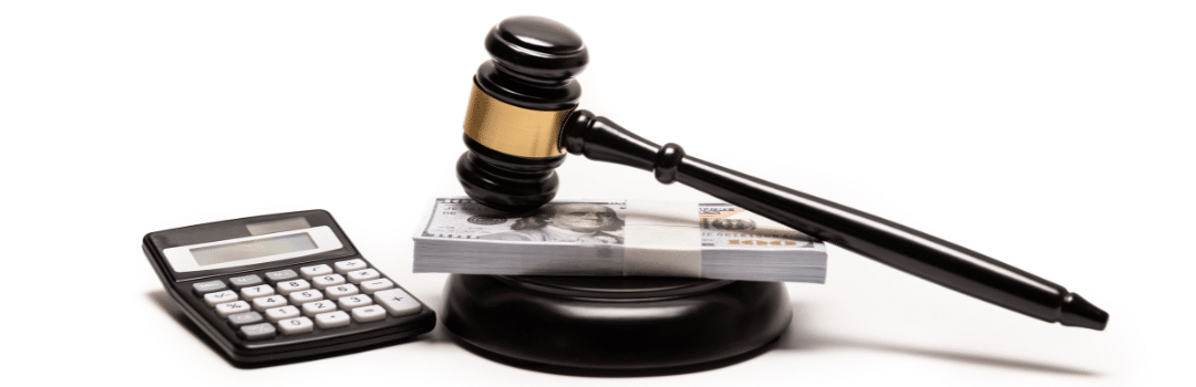 stack of money on gavel next to calculator